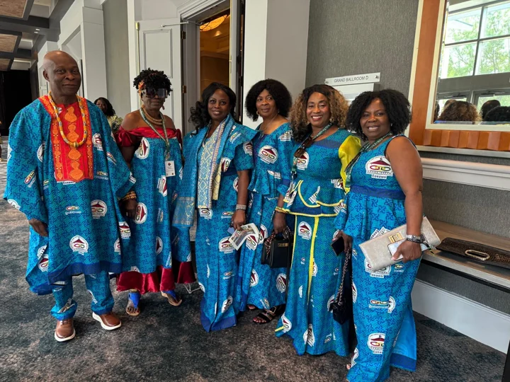 A group in blue traditional attire inside the convention venue