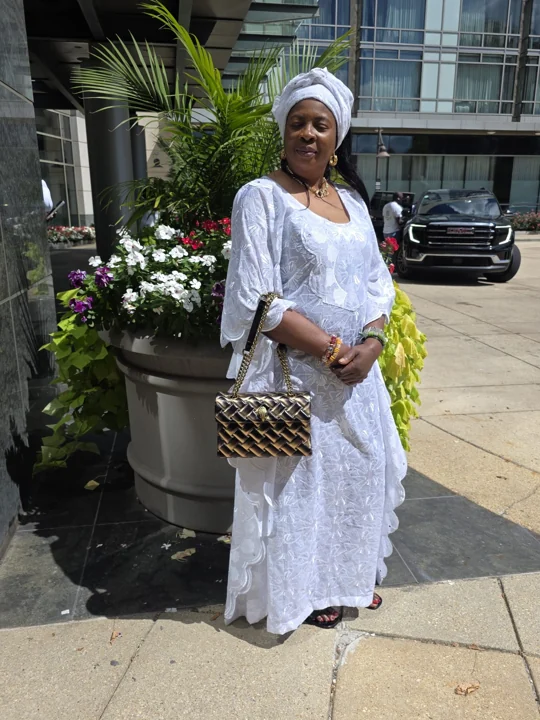 A convention guest in white traditional attire outside the hotel