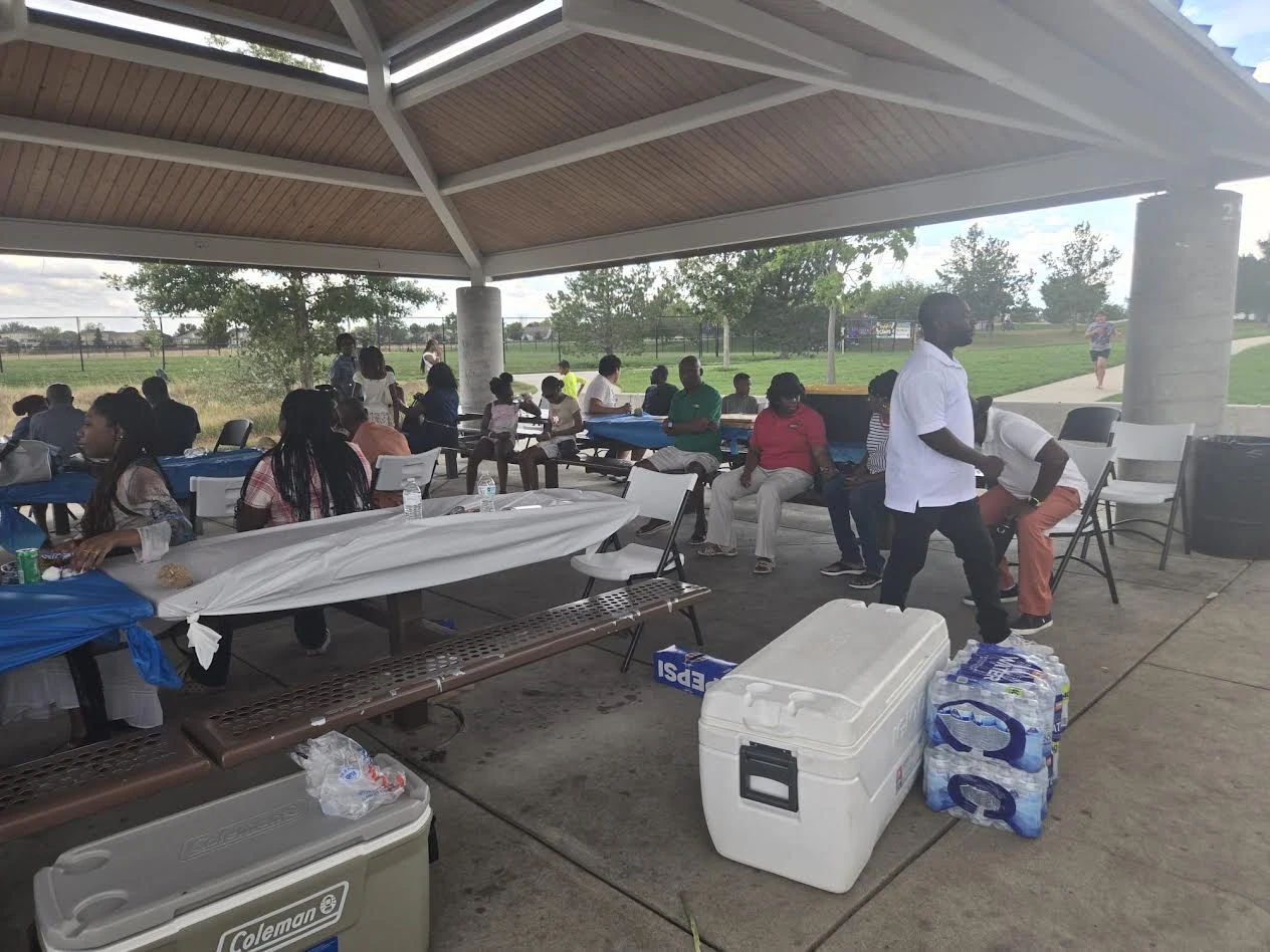 Picnic guests visiting beneath a park pavilion in Colorado